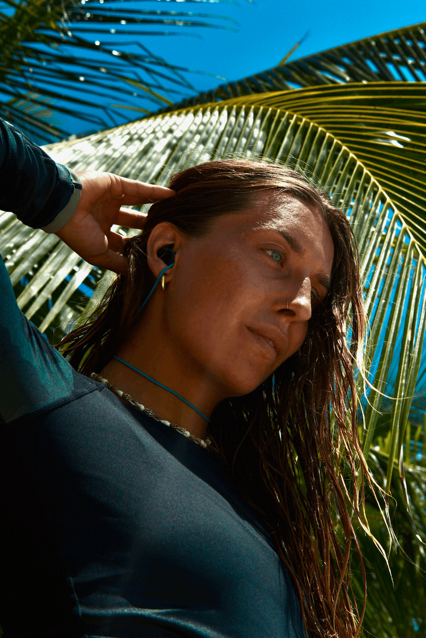 Julia wearing SEAR earplugs, surfing gear on